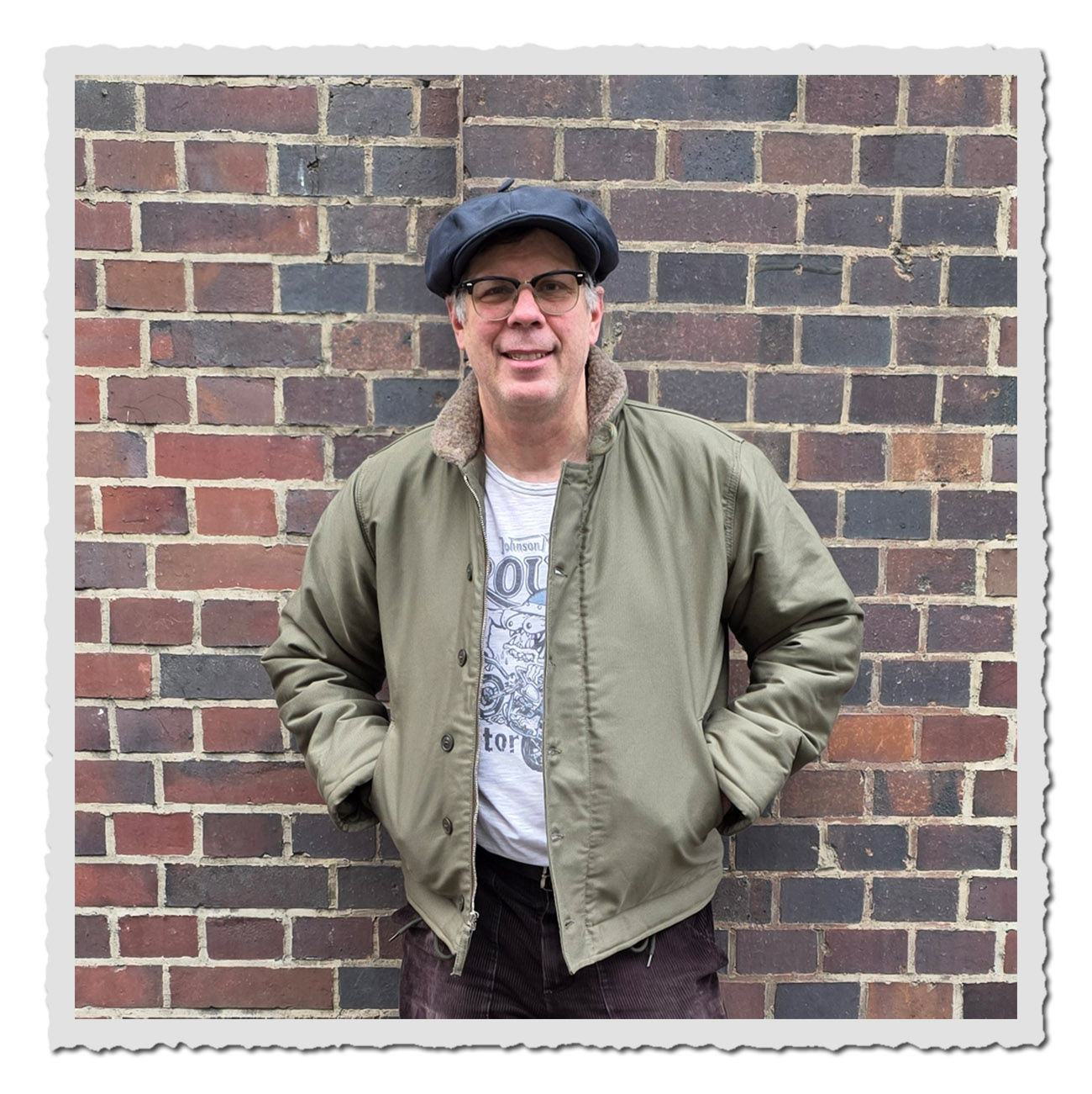 Mann lächelt in der grünen 1943 N1 Deck Jacket Bangor Green mit Wollkragen.